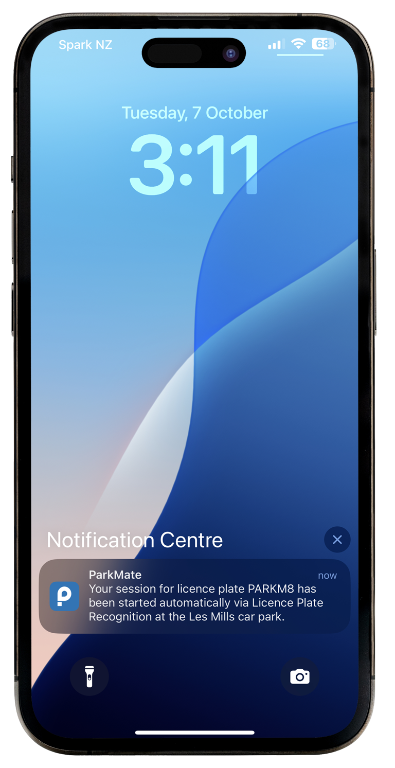 A smartphone displaying a notification from the ParkMate app indicating that a parking session has started automatically for the licence plate PARKM8 at the Les Mills car park.
